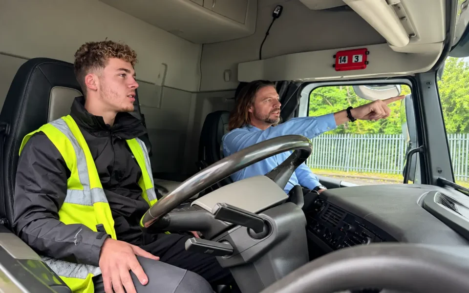 Photo of a driver in the cab of a truck with a instructor - Monex Academy driving experience